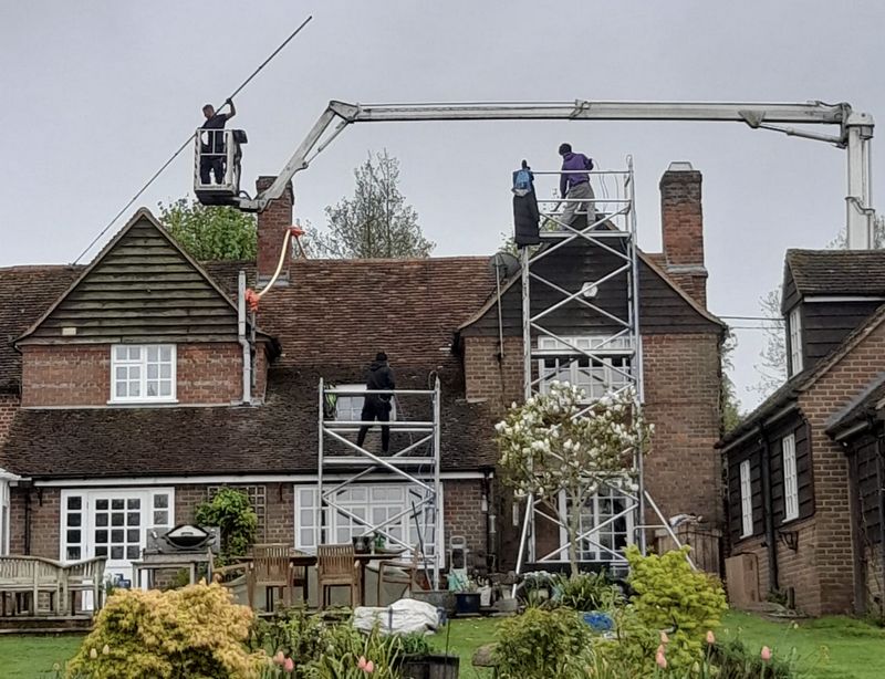 The Roof Moss Cleaners using cherry picker and scaffolding to clean roof safely and professionally in Oundle, Northamptonshire